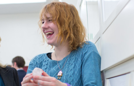 Student smiles while holding a rock.