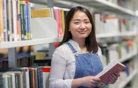 Student in the library holds a book