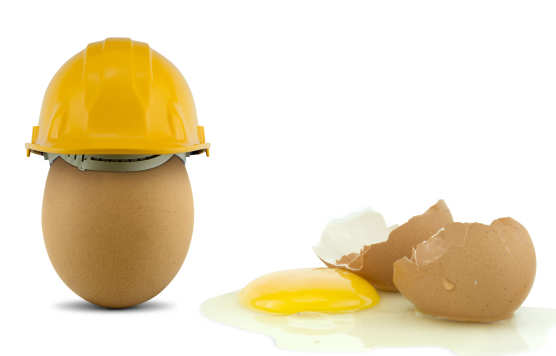 An egg with a safety helmet and a broken egg without a helmet