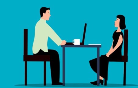 two people sitting at a desk for an interview