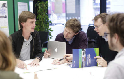 Academics on a table with laptop and publications