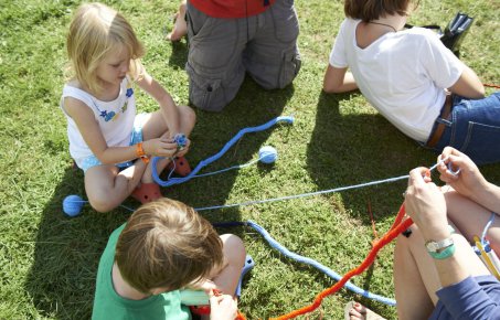 Children knit on lawn