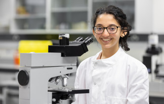 A student using a microscope in a laboratory 