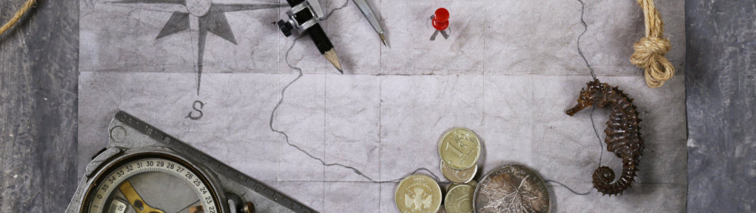 Photograph of map, compas and coins
